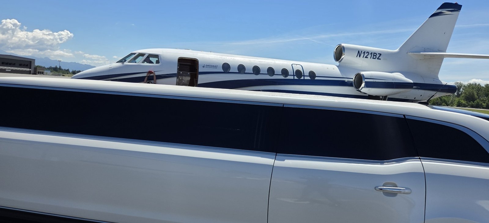 White stretch limousine beside a private jet at Skagit Regional Airport
