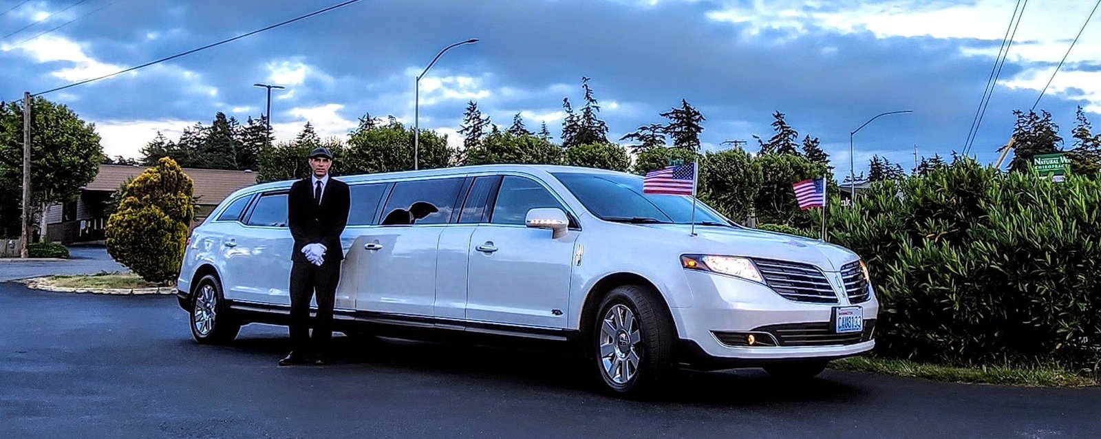 White stretch limousine and chauffeur in Oak Harbor