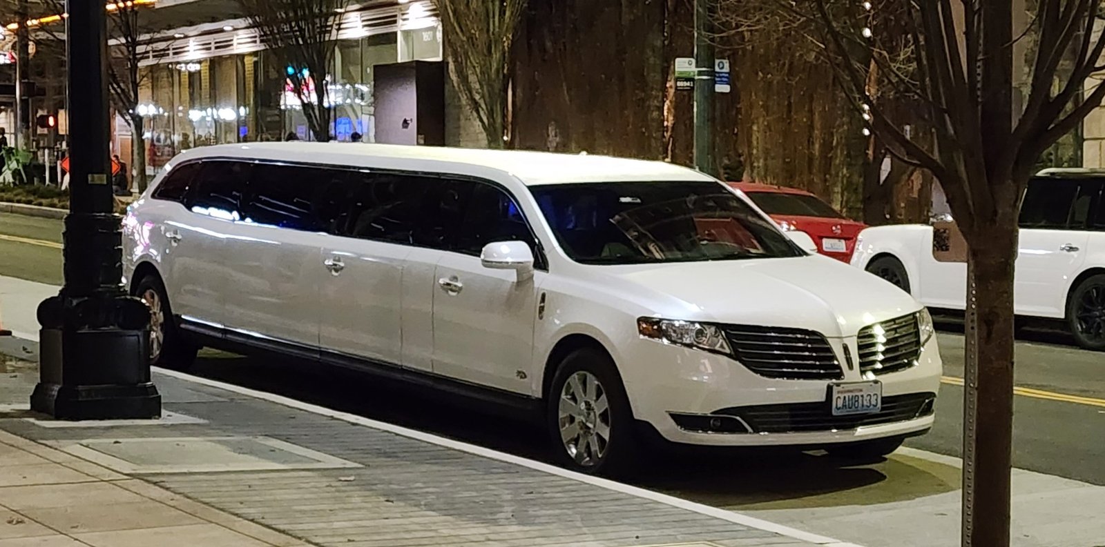 White Lincoln stretch limousine parked on a Seattle street at night